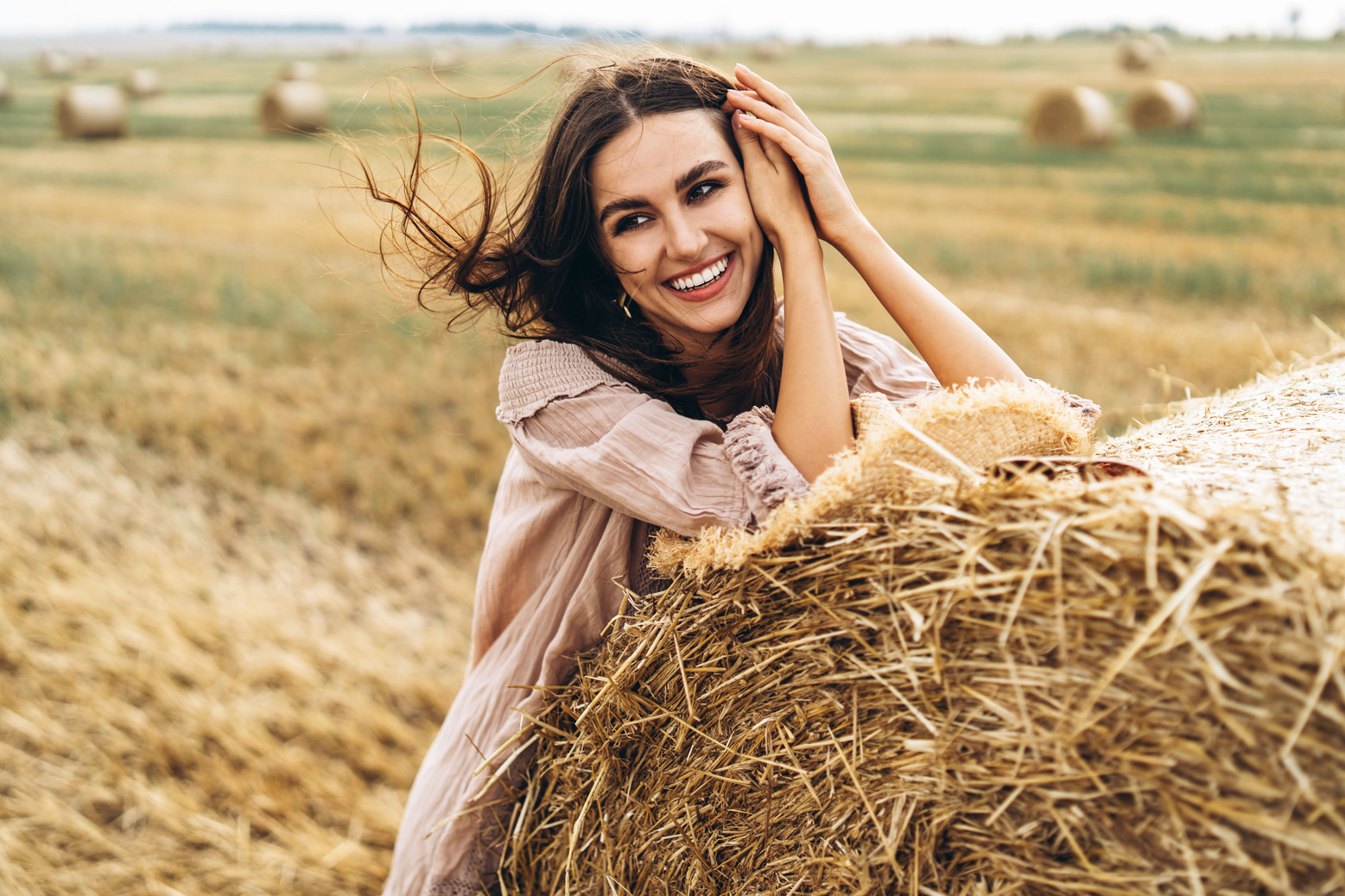 Portrait of Woman Standing by a Bale of Hay